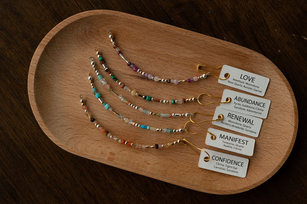 Set of beaded bracelets on a wooden tray with corresponding labels