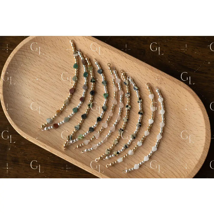 Set of beaded bracelets on a wooden tray
