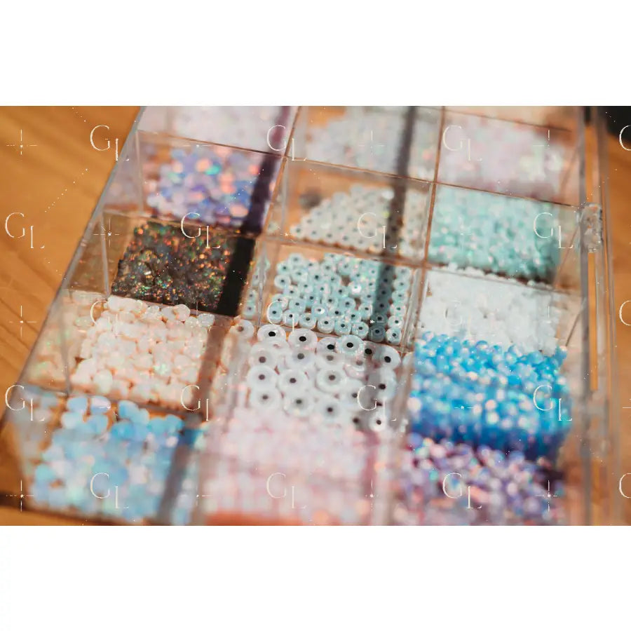 Assorted beads in a clear container on a wooden surface opal connectors