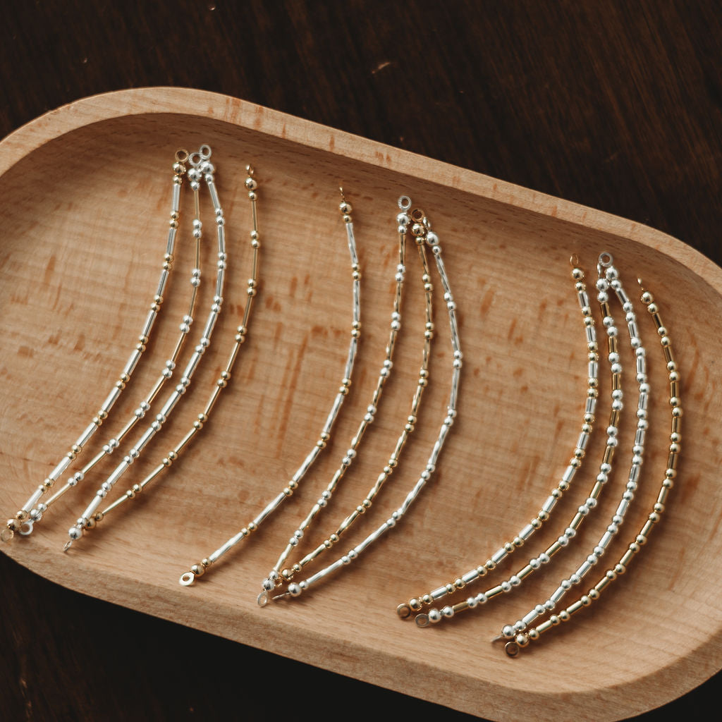 Silver beaded bracelet on a wooden tray