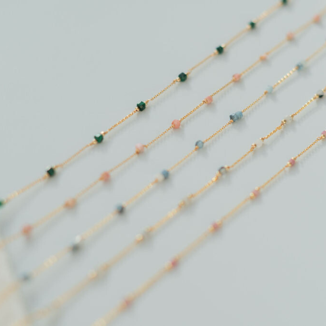 Three beaded necklaces on a light gray background