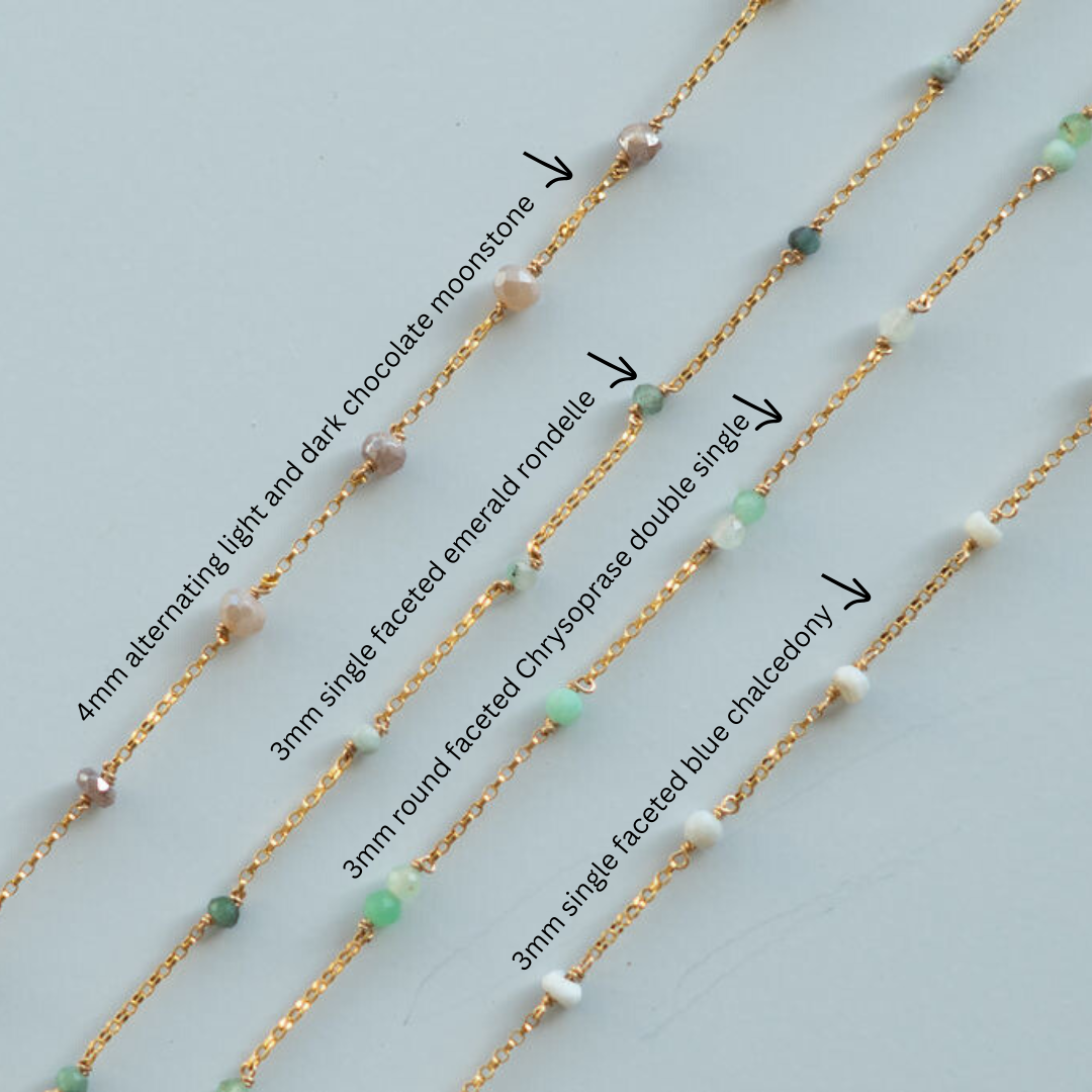Gold fill chains with various gemstones on a light blue background