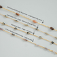 Four gold chains with different bead designs on a light gray background