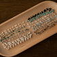Wooden tray with bracelets on a dark wooden surface