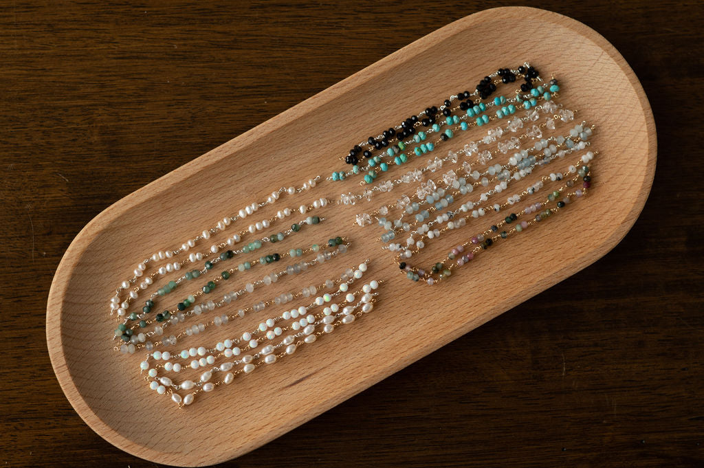Wooden tray with bracelets on a dark wooden surface