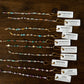 Set of beaded bracelets with corresponding labels on a wooden surface