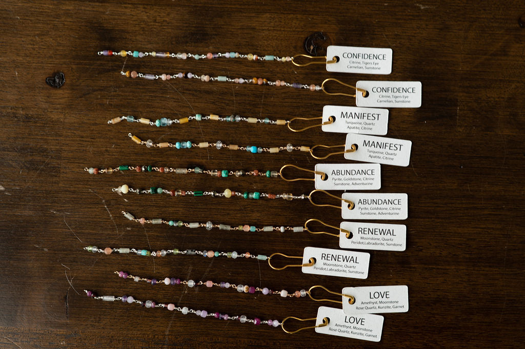 Set of beaded bracelets with corresponding labels on a wooden surface