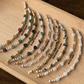 Set of beaded bracelets on a wooden board with labels for each type of stone.