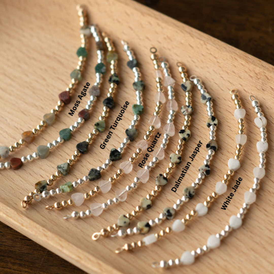 Set of beaded bracelets on a wooden board with labels for each type of stone.