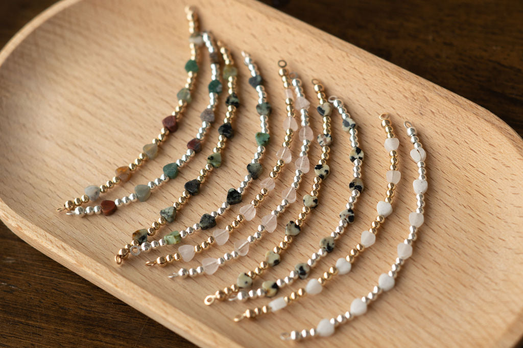 Set of beaded bracelets on a wooden tray