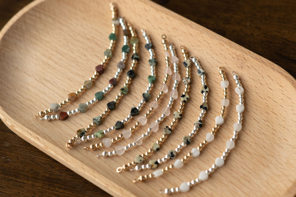 Set of beaded bracelets on a wooden tray