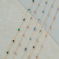 Gold necklaces with small beads on a light background