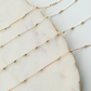 Three gold fill chain of different lengths on a marble surface