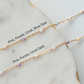 Two gold necklaces with pink, purple, and coral opal beads on a marble surface.