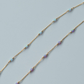 Gold  fill chain necklace with small beads on a light blue background