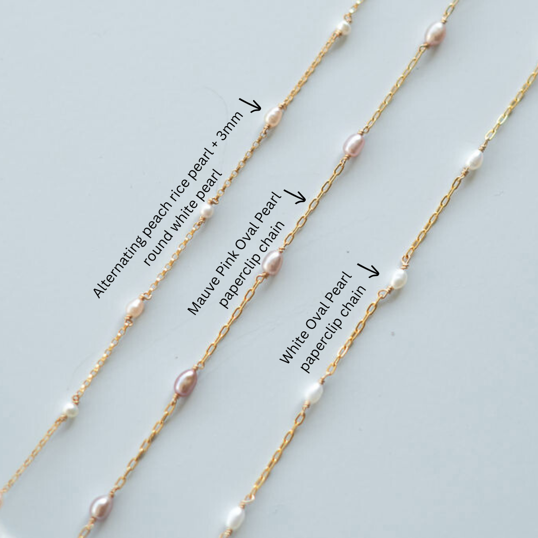 Three gold necklaces with pearl accents on a light gray background