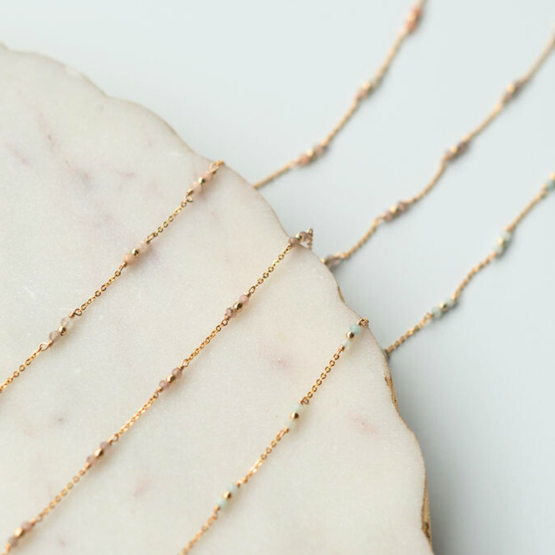 Gold fill chain necklaces on a marble surface