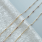 Gold chain necklace with small beads on a white towel