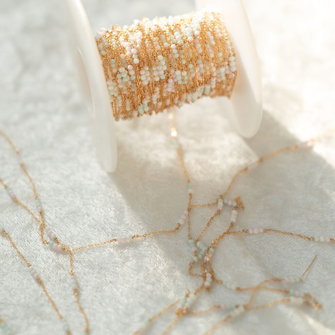 Close-up of a spool of gold thread on a marble surface