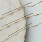 Three gold necklaces with gemstones on a marble surface