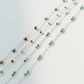 Multiple beaded necklaces on a light gray background