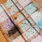 Assorted colorful beads in a clear container on a wooden surface