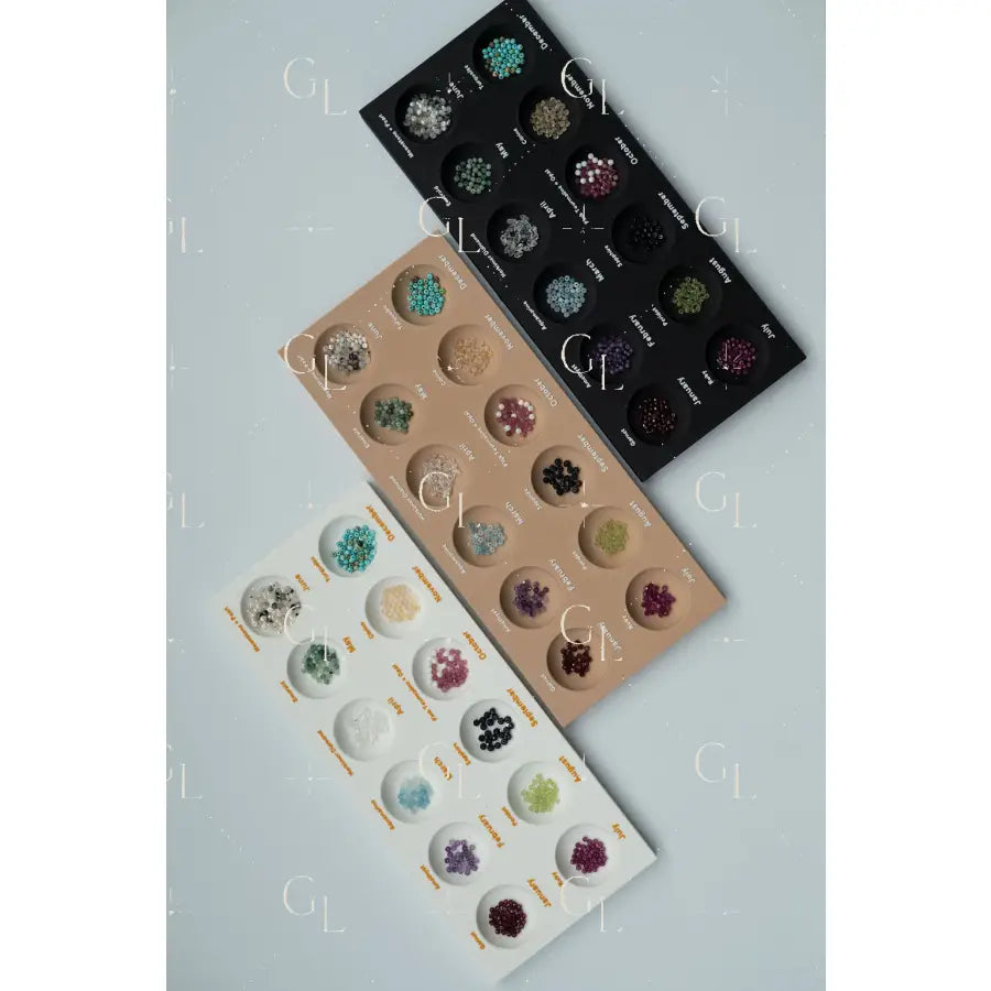 Three trays of gemstone samples on a light gray background