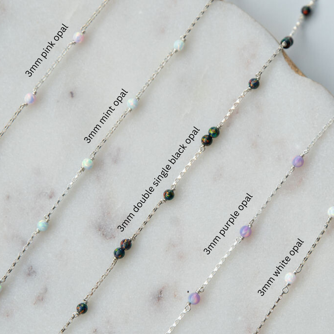 gold fill sterling silver chain with colored opal beads on a marble surface