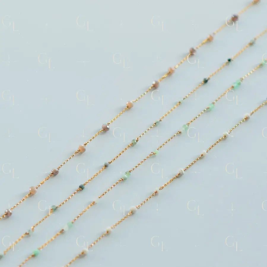 Three gold necklaces with small beads on a light blue background