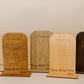 Set of wooden display stands with engraved text on a white background