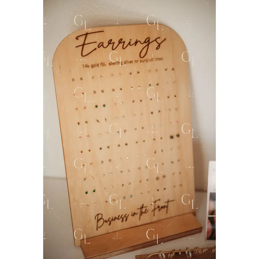 Wooden earring display board with 'Earrings' and 'Business in the Front' text on a white background.