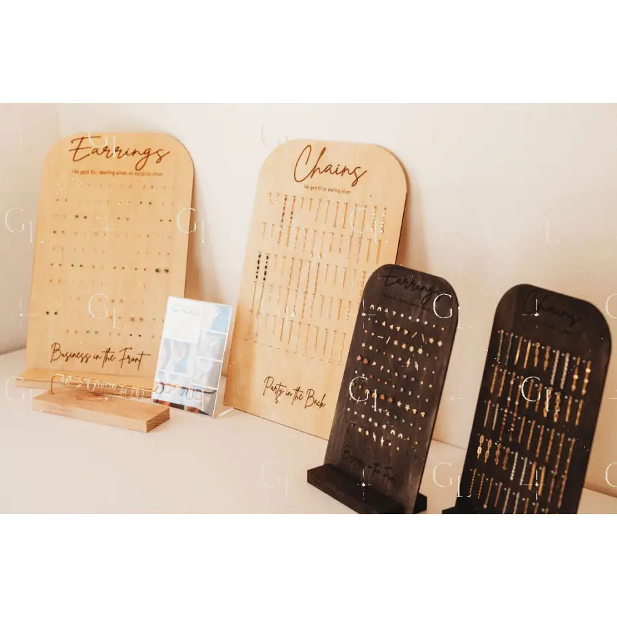 Wooden jewelry display stands with engraved text on a neutral background