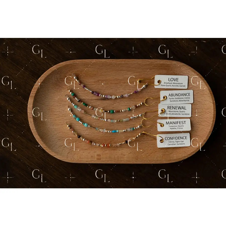 Set of beaded bracelets on a wooden tray with corresponding cards on a dark surface