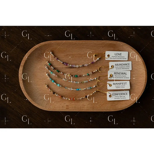 Set of beaded bracelets on a wooden tray with corresponding cards on a dark surface