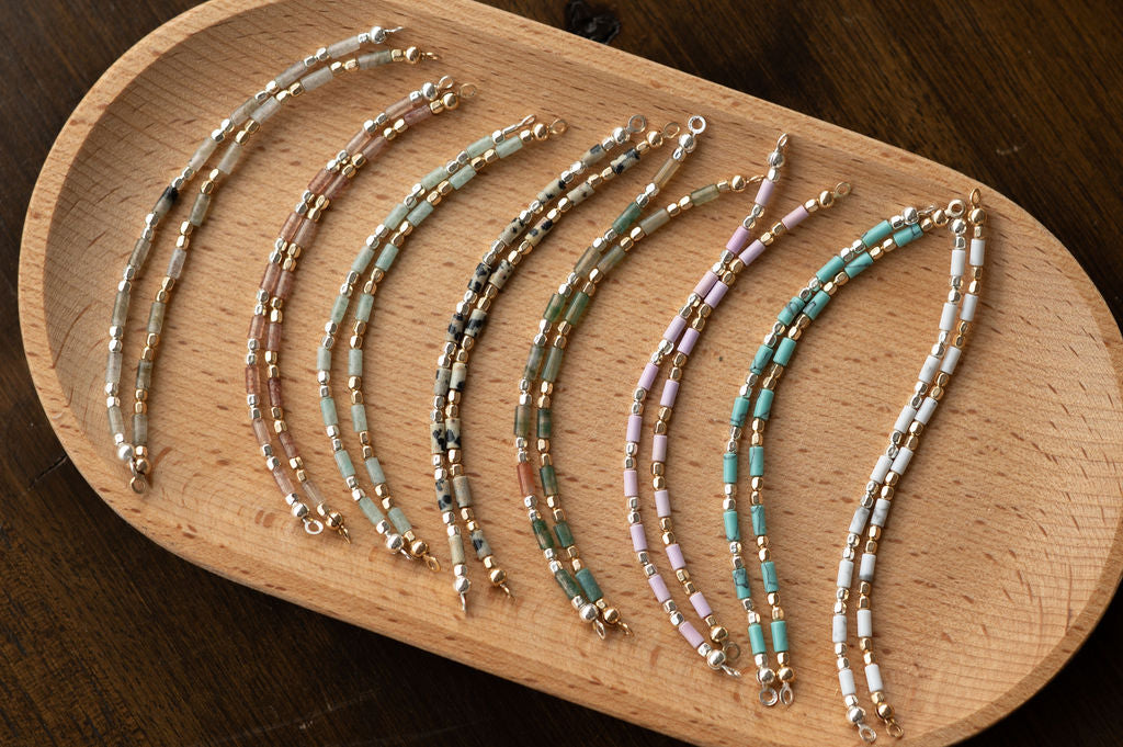 Set of beaded bracelets on a wooden tray