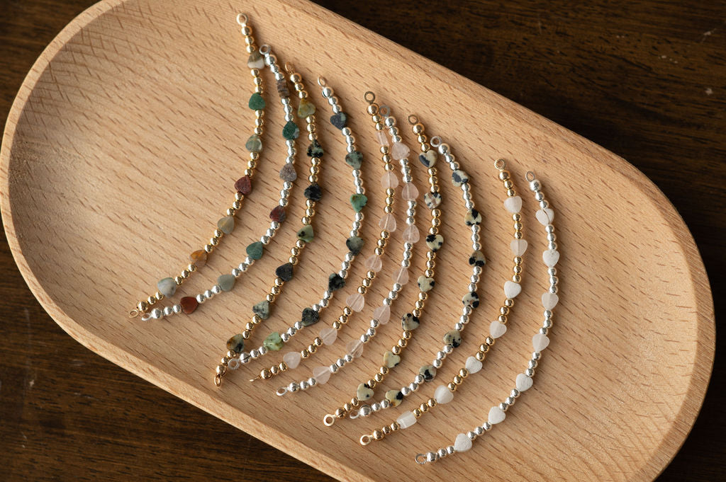 Set of beaded bracelets on a wooden tray