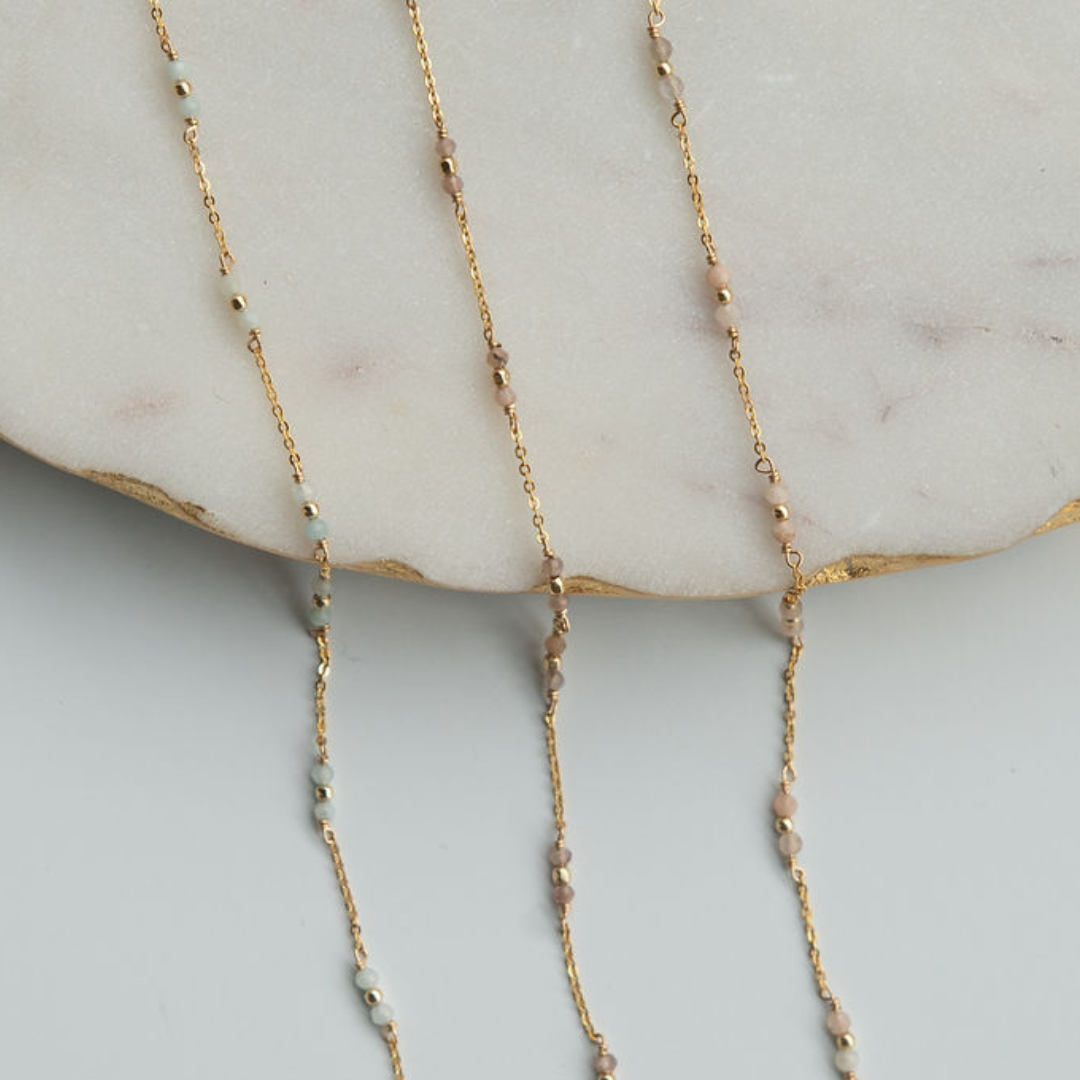 Gold fill necklace with small beads on a marble surface