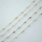 Gold necklaces with small beads on a light gray background