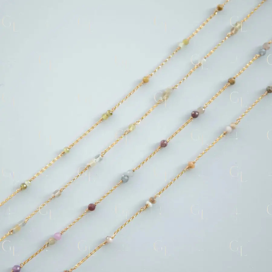 Gold necklaces with small beads on a light gray background