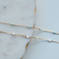 Gold chain necklace with small beads on a marble surface
