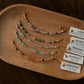 Set of beaded bracelets on a wooden tray with corresponding labels