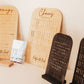 Wooden jewelry display stands with engraved text on a neutral background
