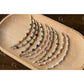 Set of beaded bracelets on a wooden tray