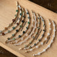 Set of beaded bracelets on a wooden board with labels for each type of stone.