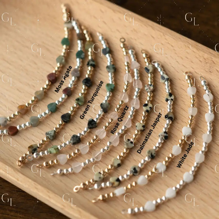 Set of beaded bracelets on a wooden board with labels for each type of stone.