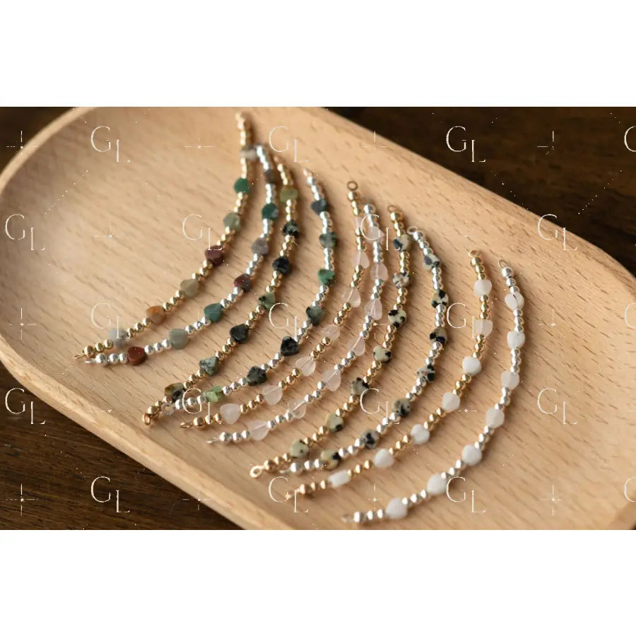 Set of beaded bracelets on a wooden tray