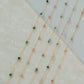 Gold necklaces with small beads on a light background