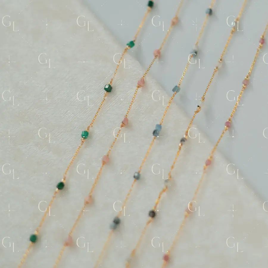 Gold necklaces with small beads on a light background