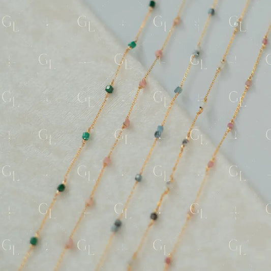 Gold necklaces with small beads on a light background