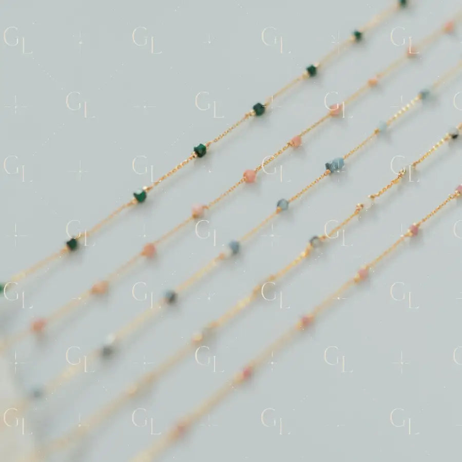 Three beaded necklaces on a light gray background